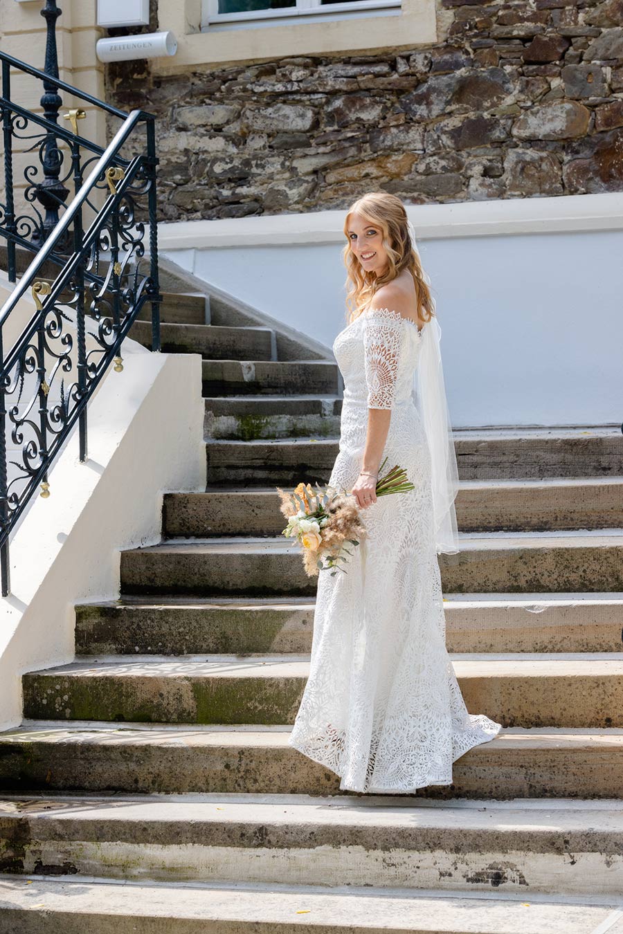 Die Braut steht am Haus Füchten in Ense auf den Stufen.