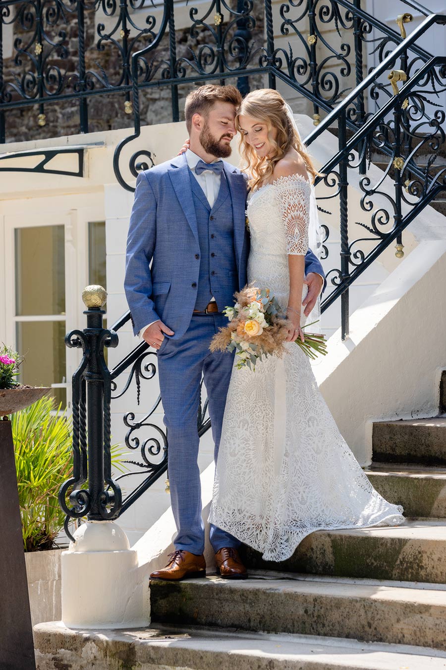 Das Brautpaar steht auf den Stufen von Haus Füchten in Ense