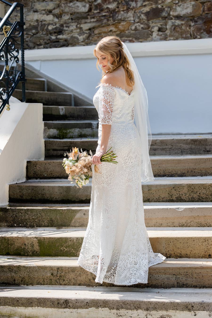 Die Braut steht am Haus Füchten in Ense auf den Stufen.