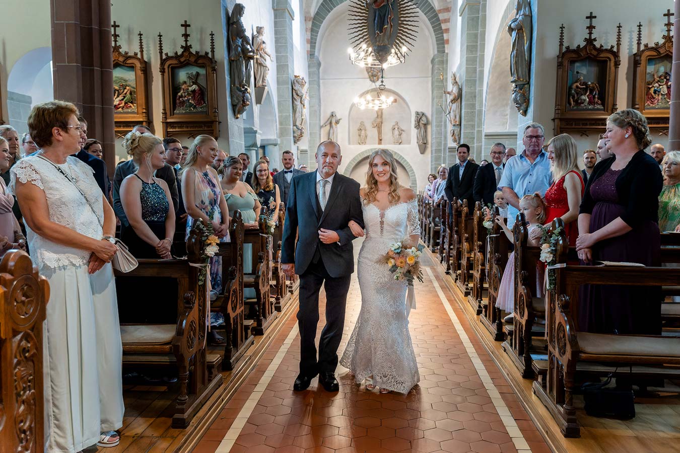 Die Braut zieht am Arm Ihres Vaters in die Kirche