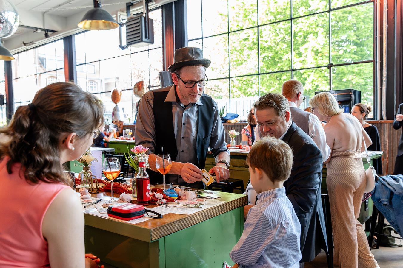 Zauberer unterhält auf der Hochzeitsparty die Gäste mit Kartentricks